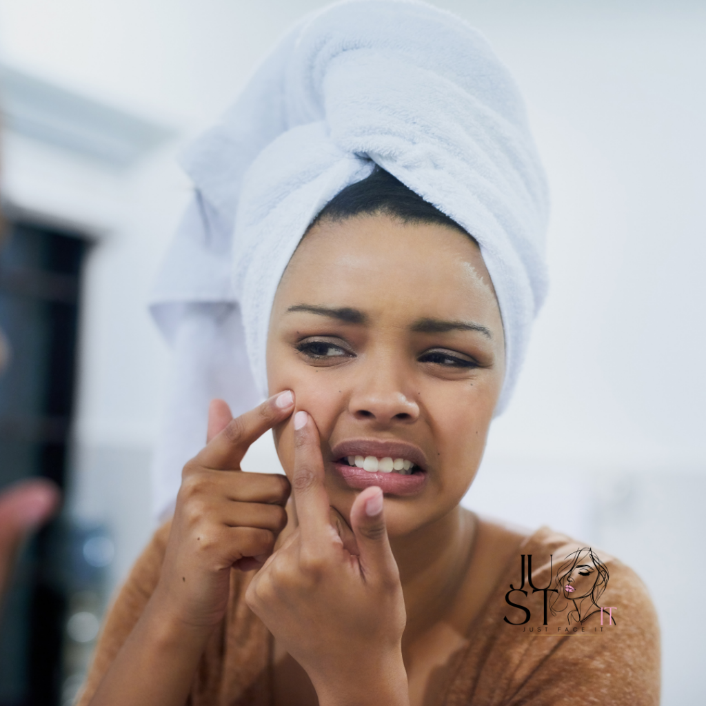 Vrouw kijkt in de spiegel terwijl ze voorzichtig een pukkel uitknijpt, gefocust op haar huidverzorgingsroutine tegen acne